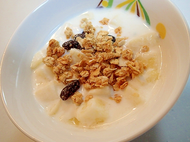 白い器に入ったグラノーラとりんごを加えたヨーグルト