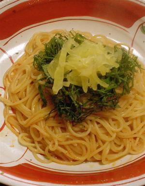 赤い模様入りの皿に盛り付けたたくあんとキムチのパスタ