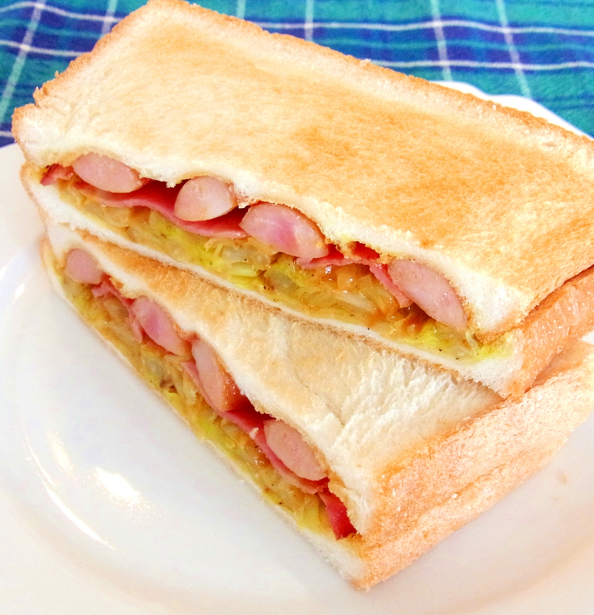 白い皿に盛り付けたキャベツとソーセージトーストサンド