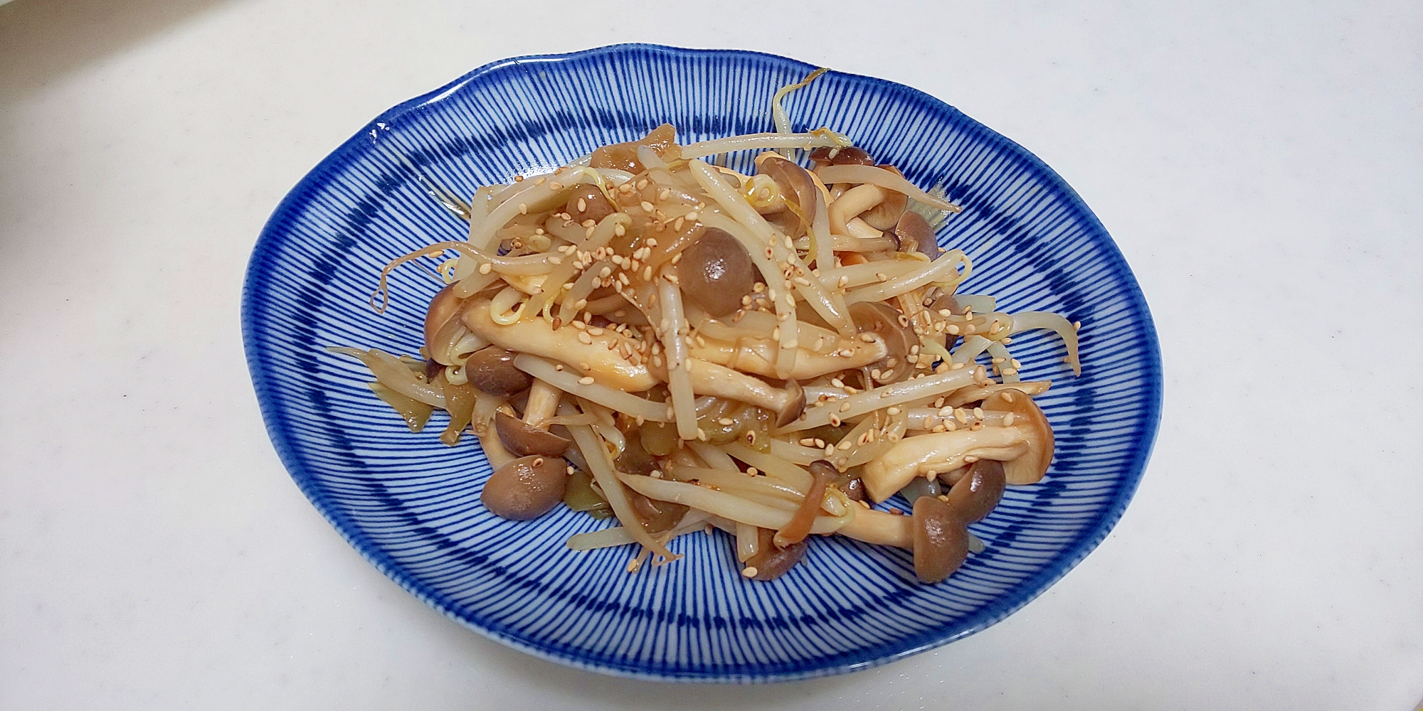 青い皿に盛り付けたもやしときのこのザーサイ炒め