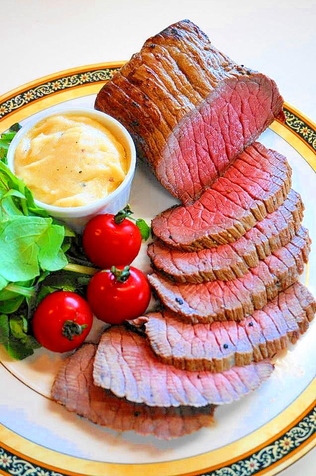 プレートに盛り付けた本格ローストビーフのグレイビーソース添え