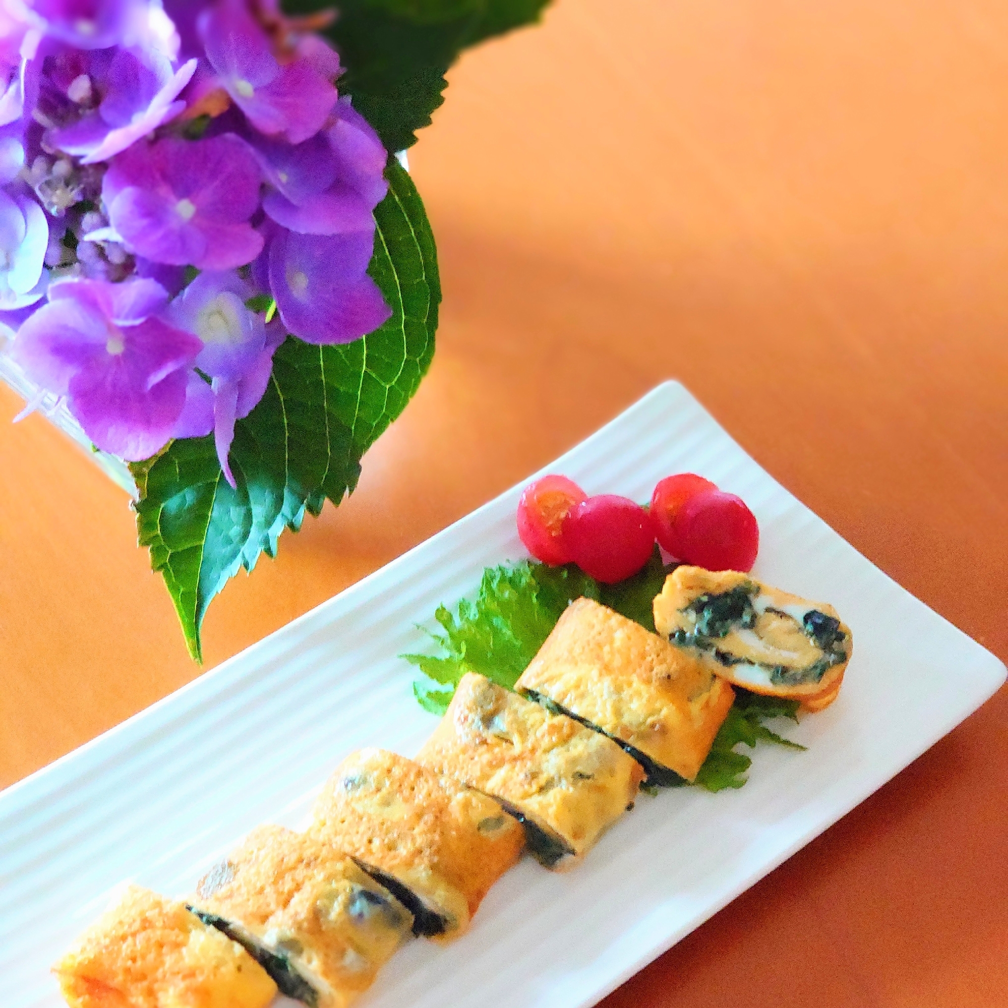 白い皿に盛られた赤しその卵焼き