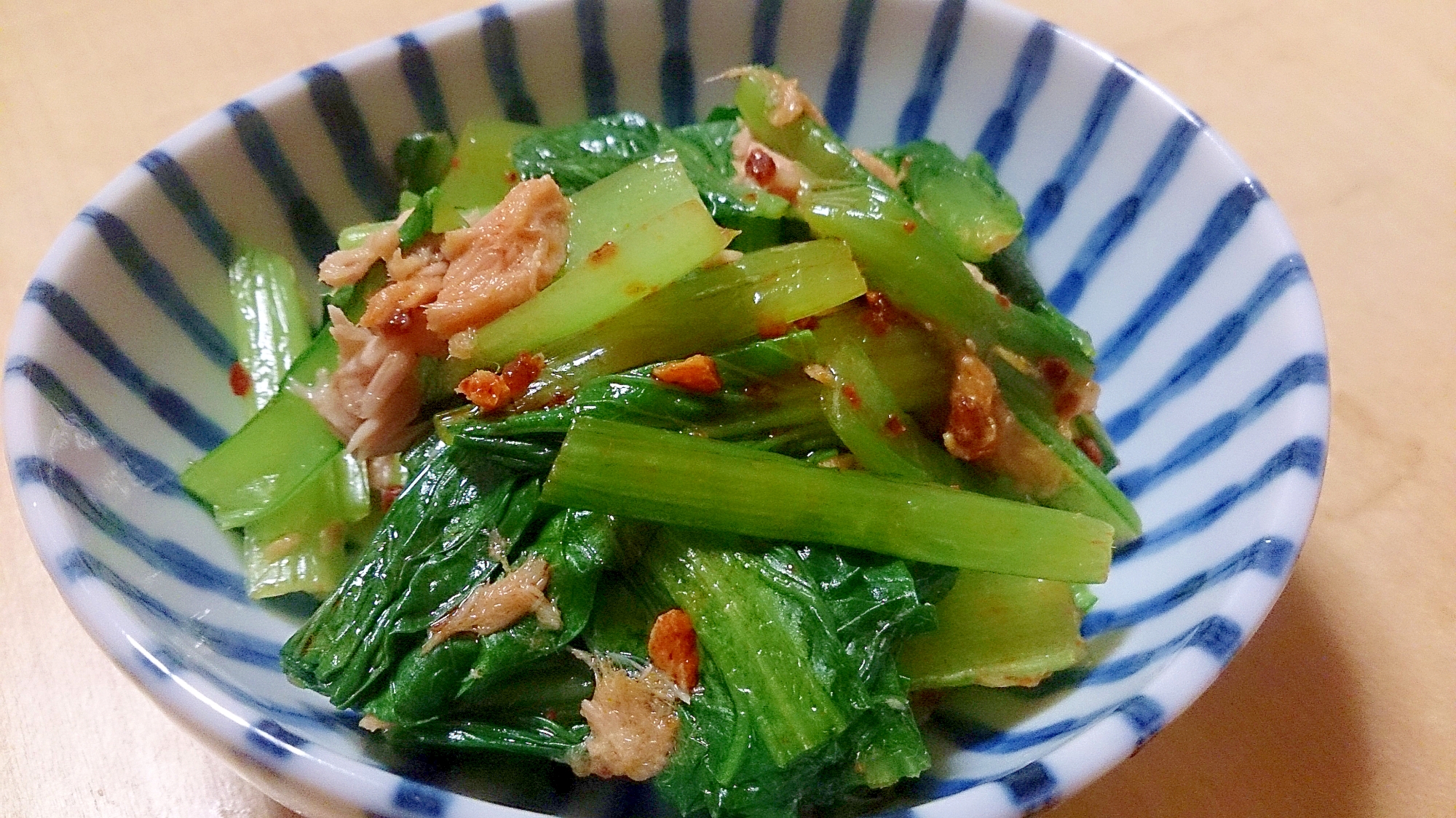 縞模様の皿に盛られたツナと小松菜の食べるラー油和え