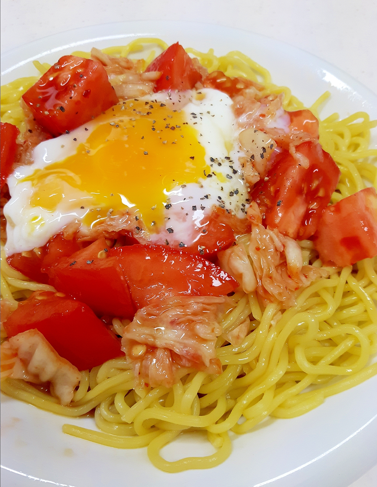 白色の皿に盛られたキムチ温玉冷やし中華