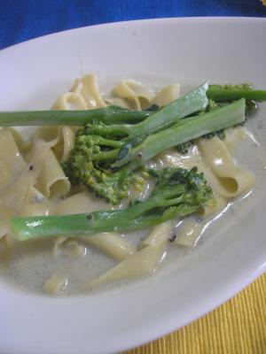 白い皿に盛り付けたスティックブロッコリーのブルーチーズソースパスタ