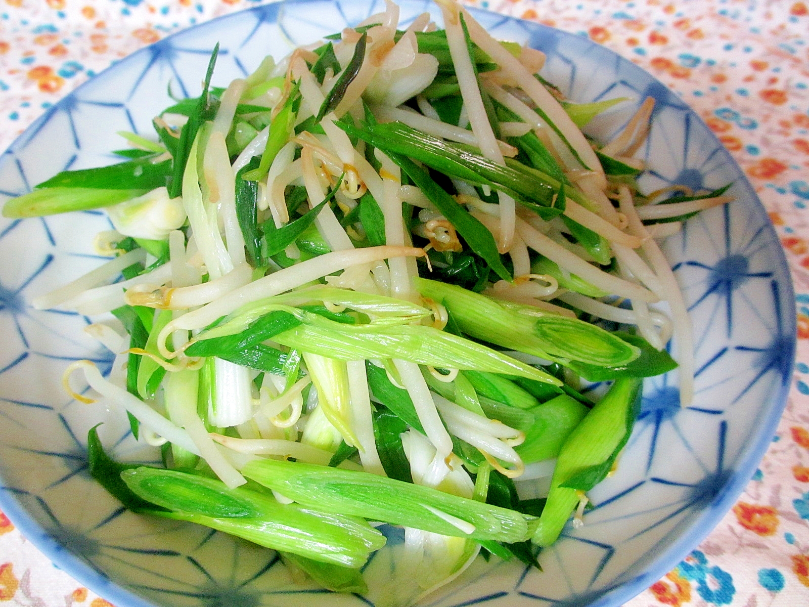 幾何学模様の器に盛り付けたもやしと葉にんにくの炒め物