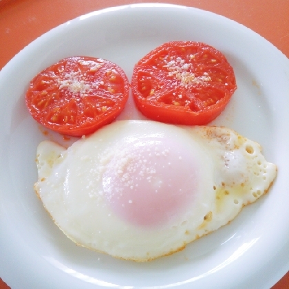 目玉焼きと一緒に焼いたトマトの粉チーズがけ