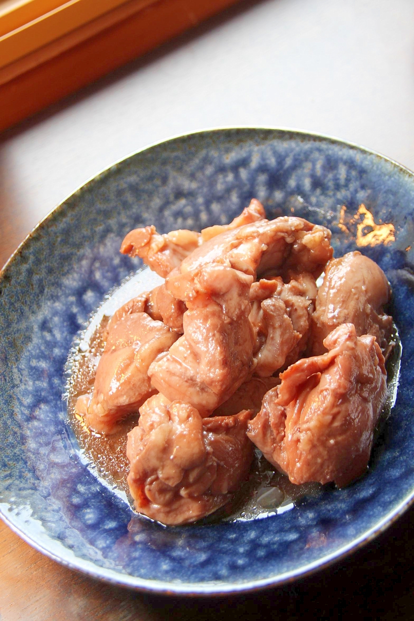 青い皿に盛られた、鶏肉のワイン煮
