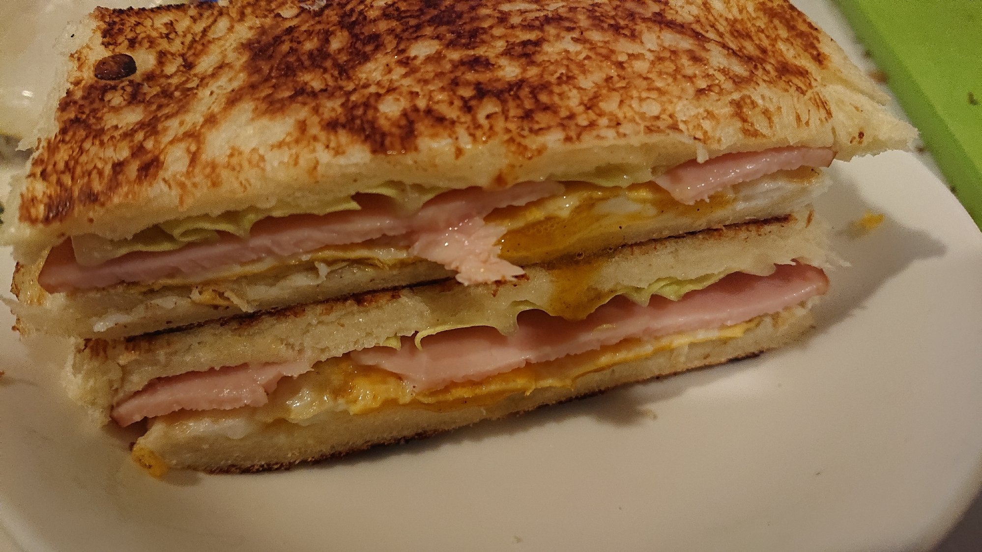 白い皿にのせられたカルボナーラソースのホットサンド