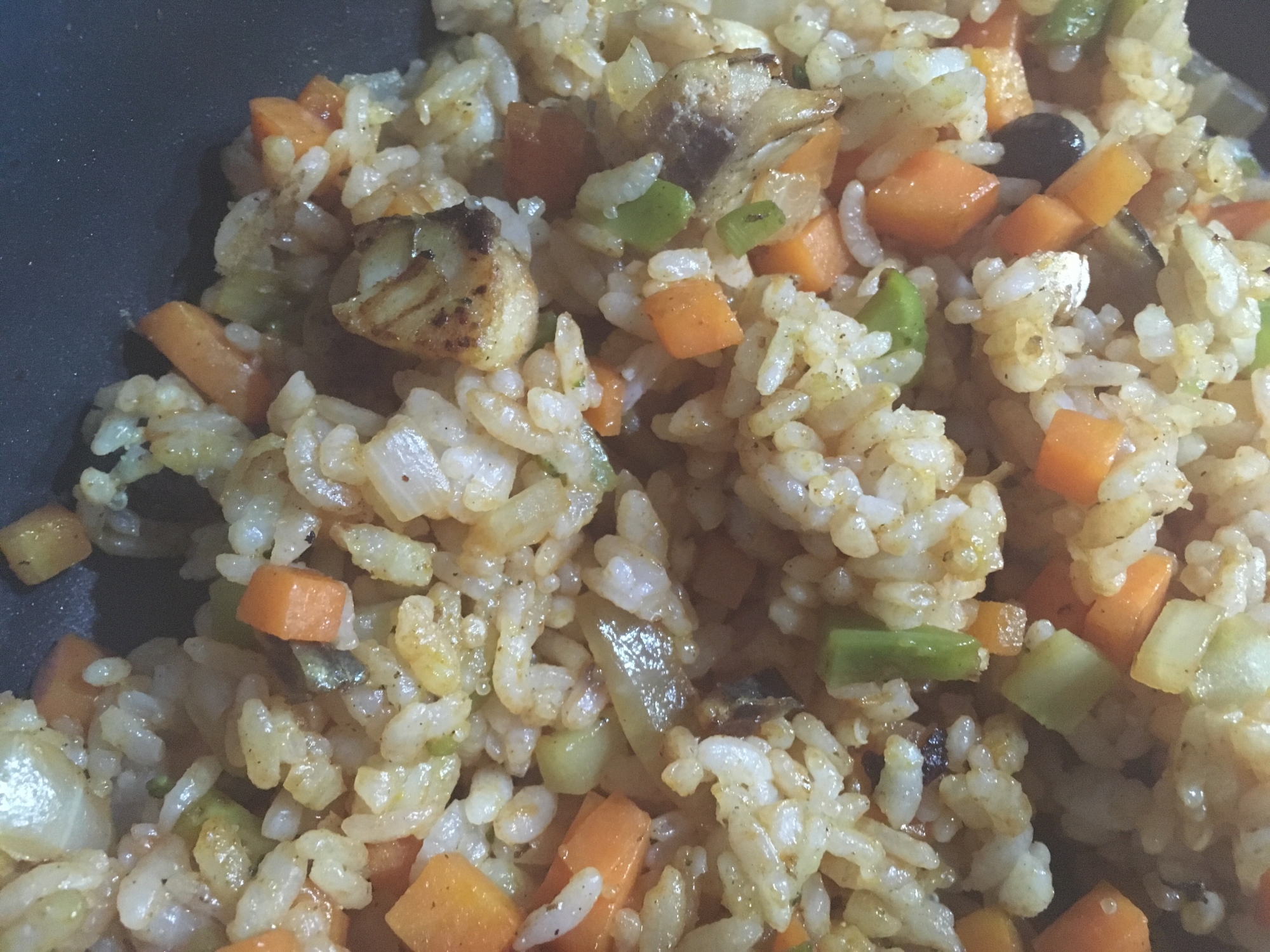 黒いお皿に盛り付けられたさばのカレーピラフ