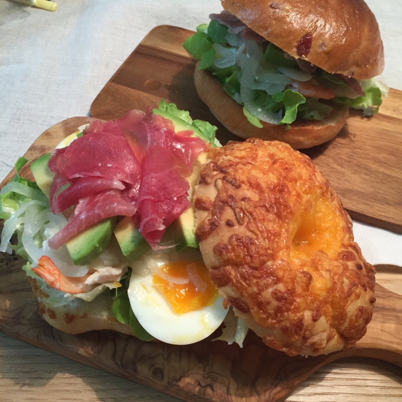 ウッドプレートに盛り付けたえびとアボカドのベーグルサンド