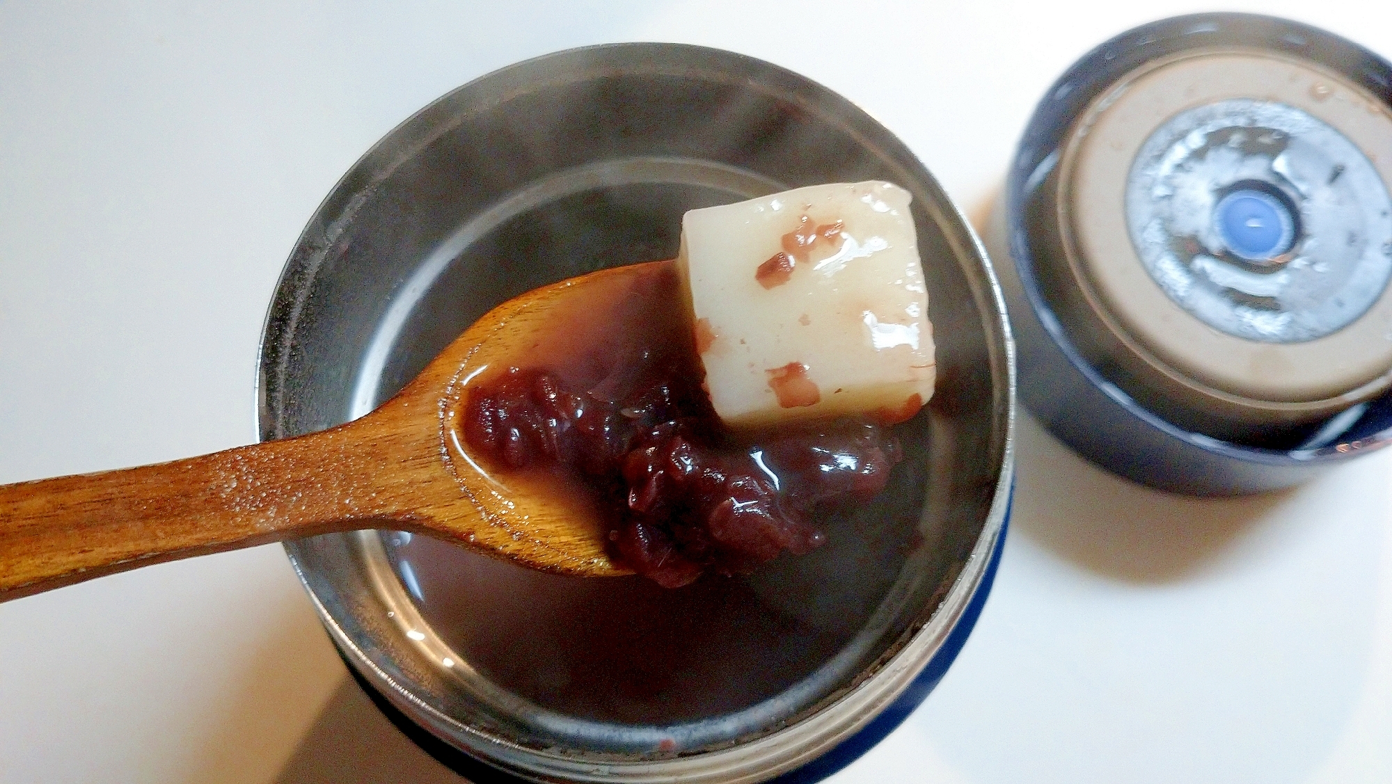 スープジャーからスプーンですくったぜんざいと餅