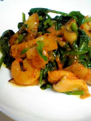 白い皿に盛り付けたアオリイカとほうれん草のケチャップ炒め