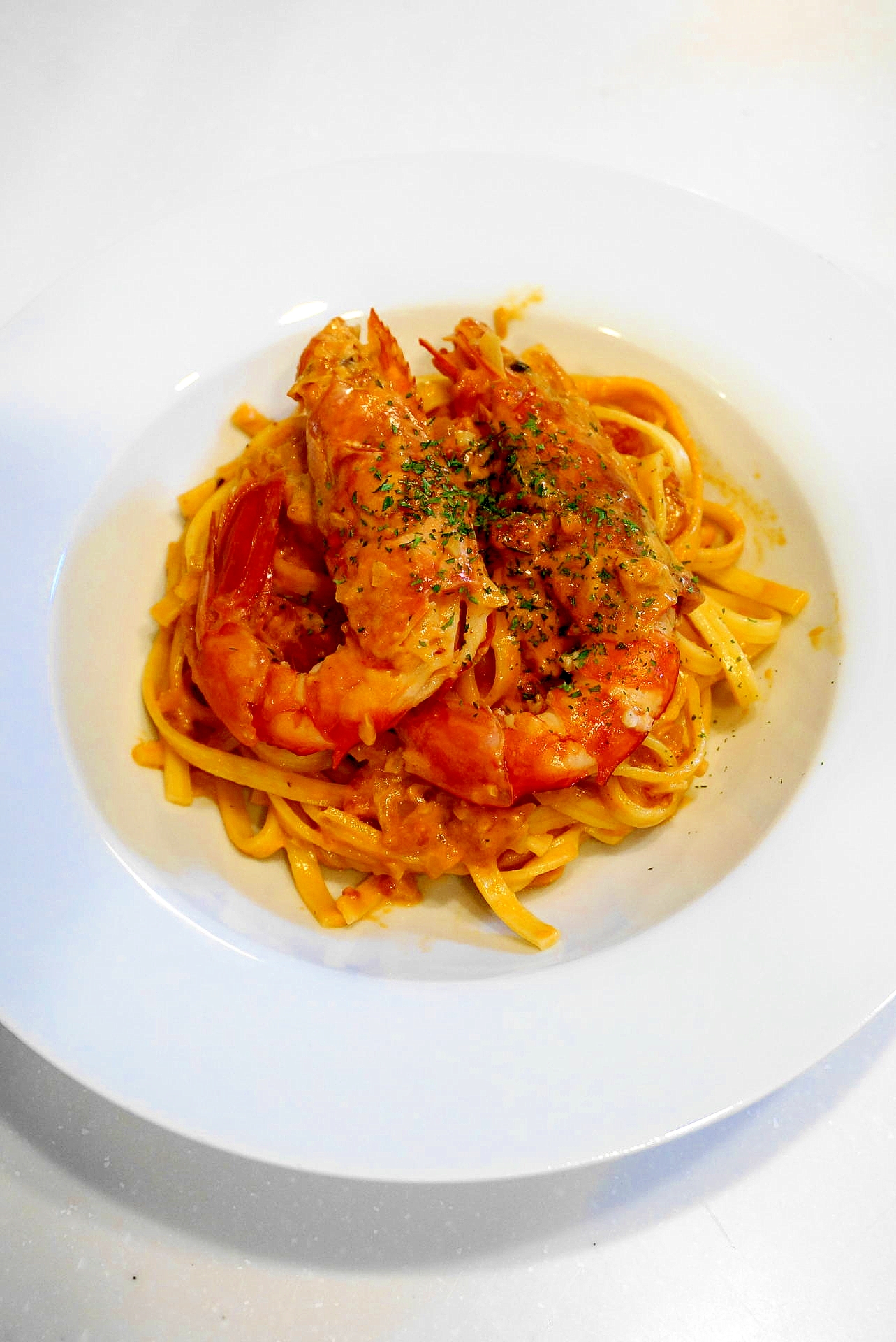 白い皿に盛られた、赤エビのトマトクリームパスタ