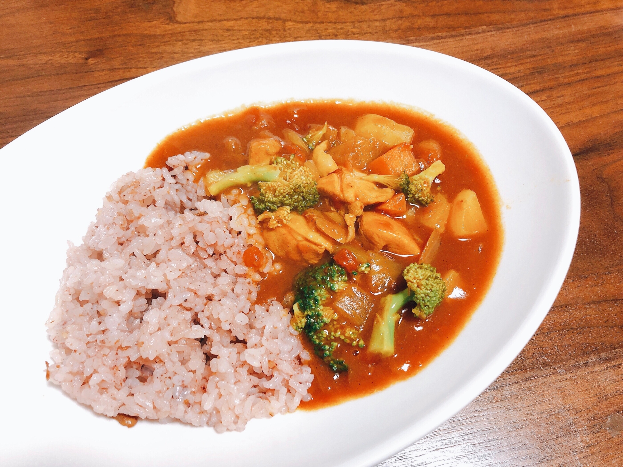 白い皿に盛り付けたトマト風味のチキンカレー