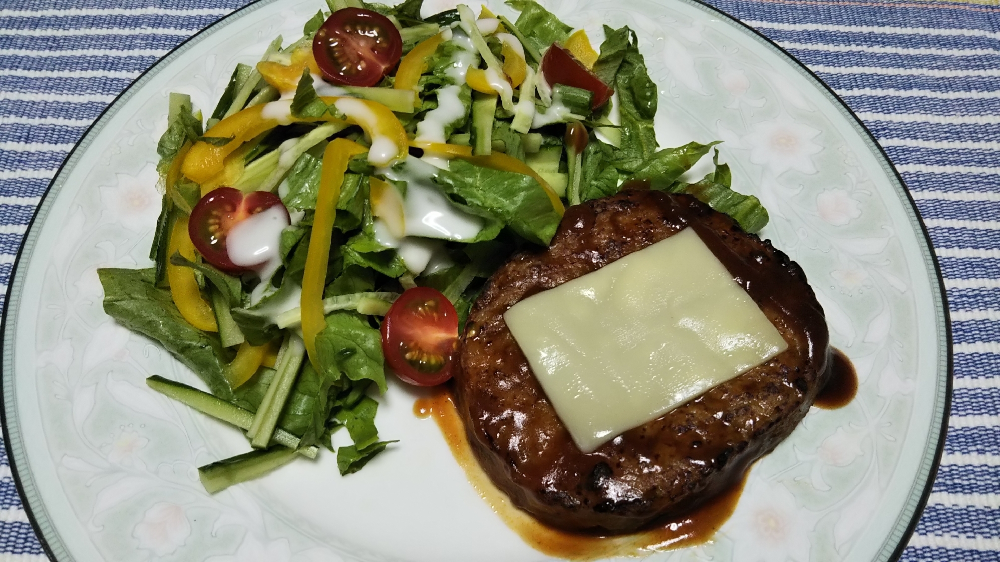 チーズのせハンバーグと野菜たっぷりサラダ付け合わせ