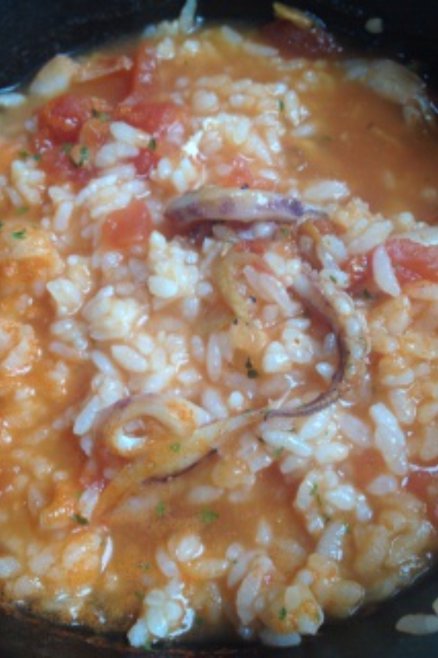 黒い器に盛り付けられたイカトマトリゾット