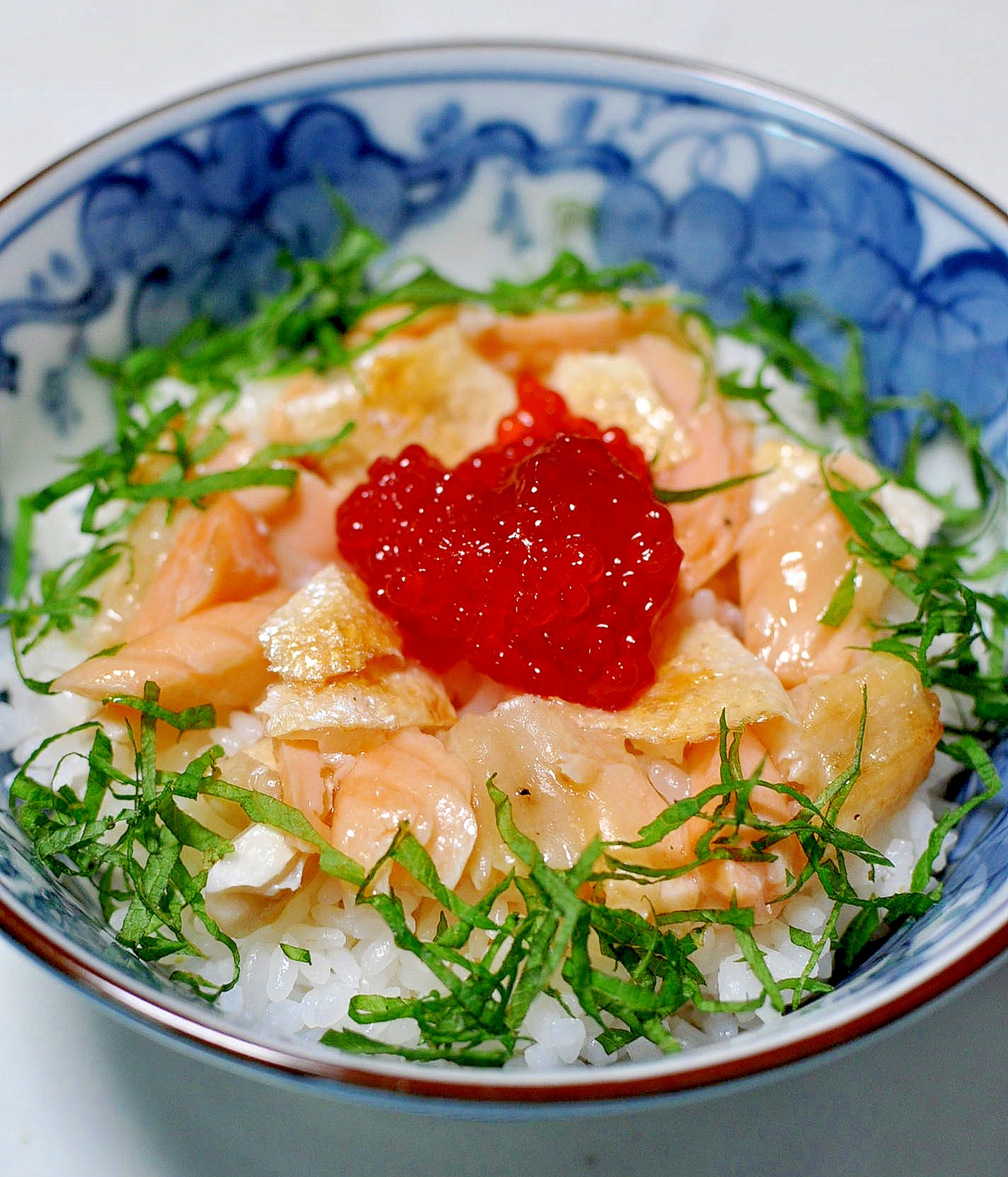 青い器に茶碗に盛り付けた筋子と鮭ハラスの親子丼