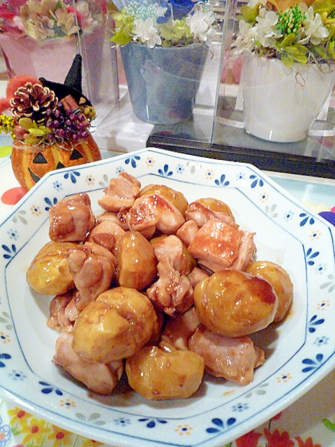 青色の花柄の皿に盛られた鶏もも肉とむき栗の甘辛炒め