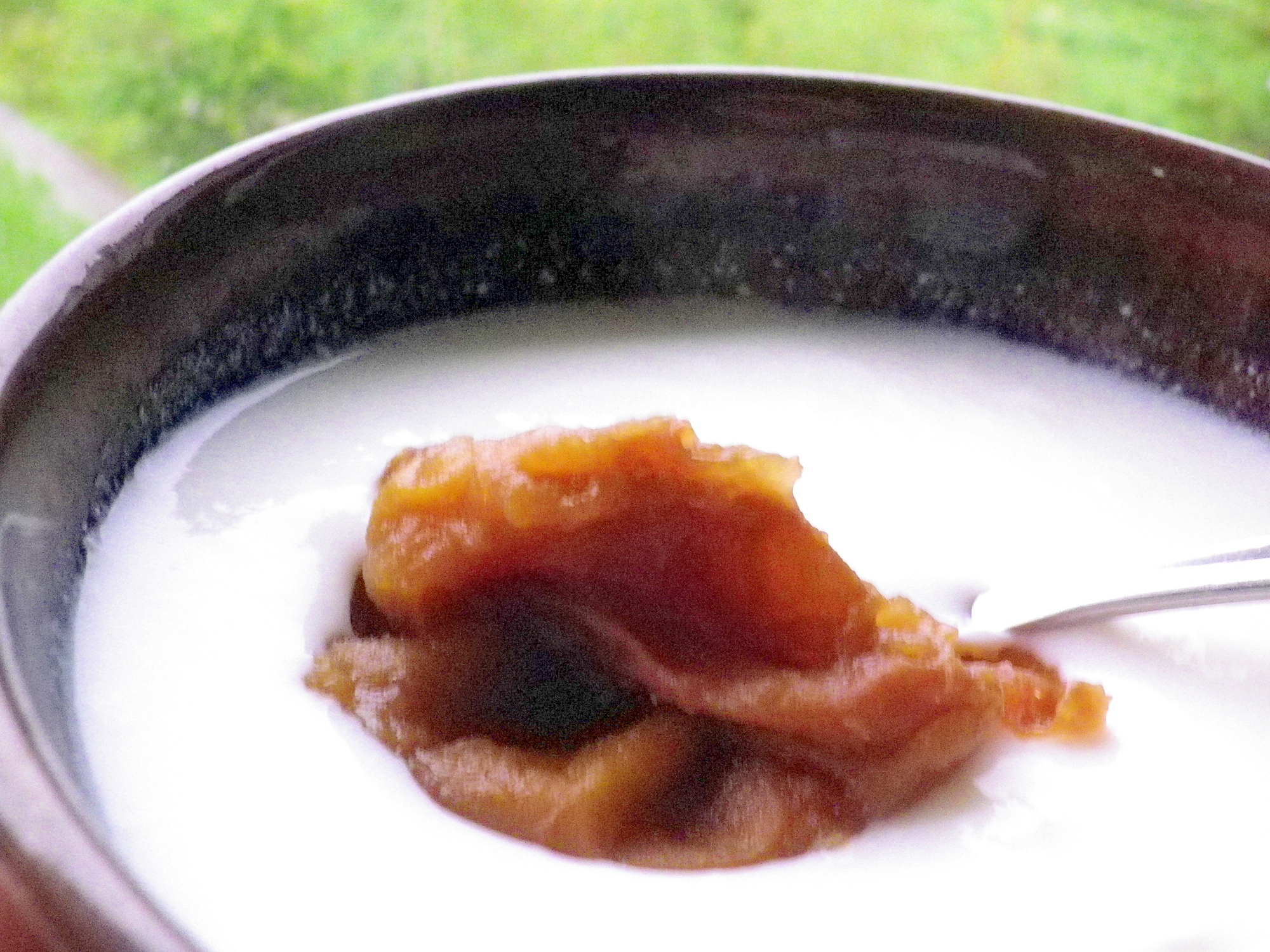 黒い器に入ったヨーグルトに梅ペーストがトッピングされている