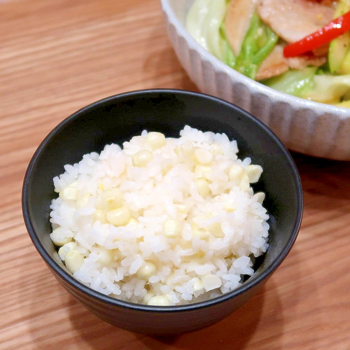 黒色の茶碗に盛られたホワイトコーンの炊き込みごはん