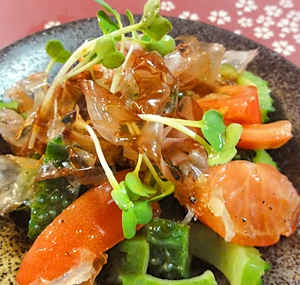 黒いお皿に盛り付けられたトマトとゴーヤの和風サラダ