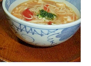 白地に青い模様入りの器に盛られた味噌汁でトマトそうめん