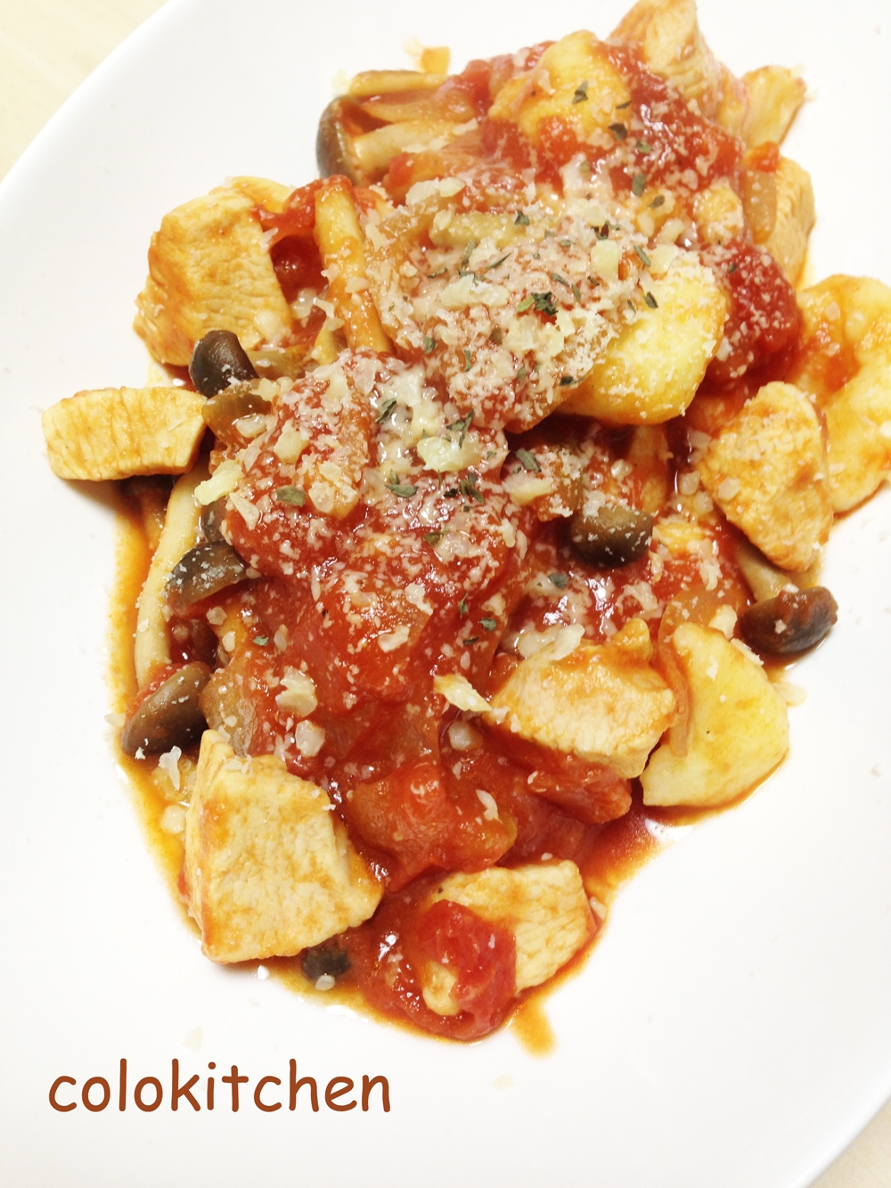 白いお皿に盛り付けられた鶏むね肉としめじのトマトソースニョッキ