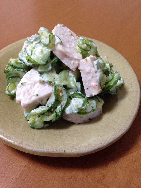 ベージュの皿に盛られた鶏ハムときゅうりのごまマヨ和え