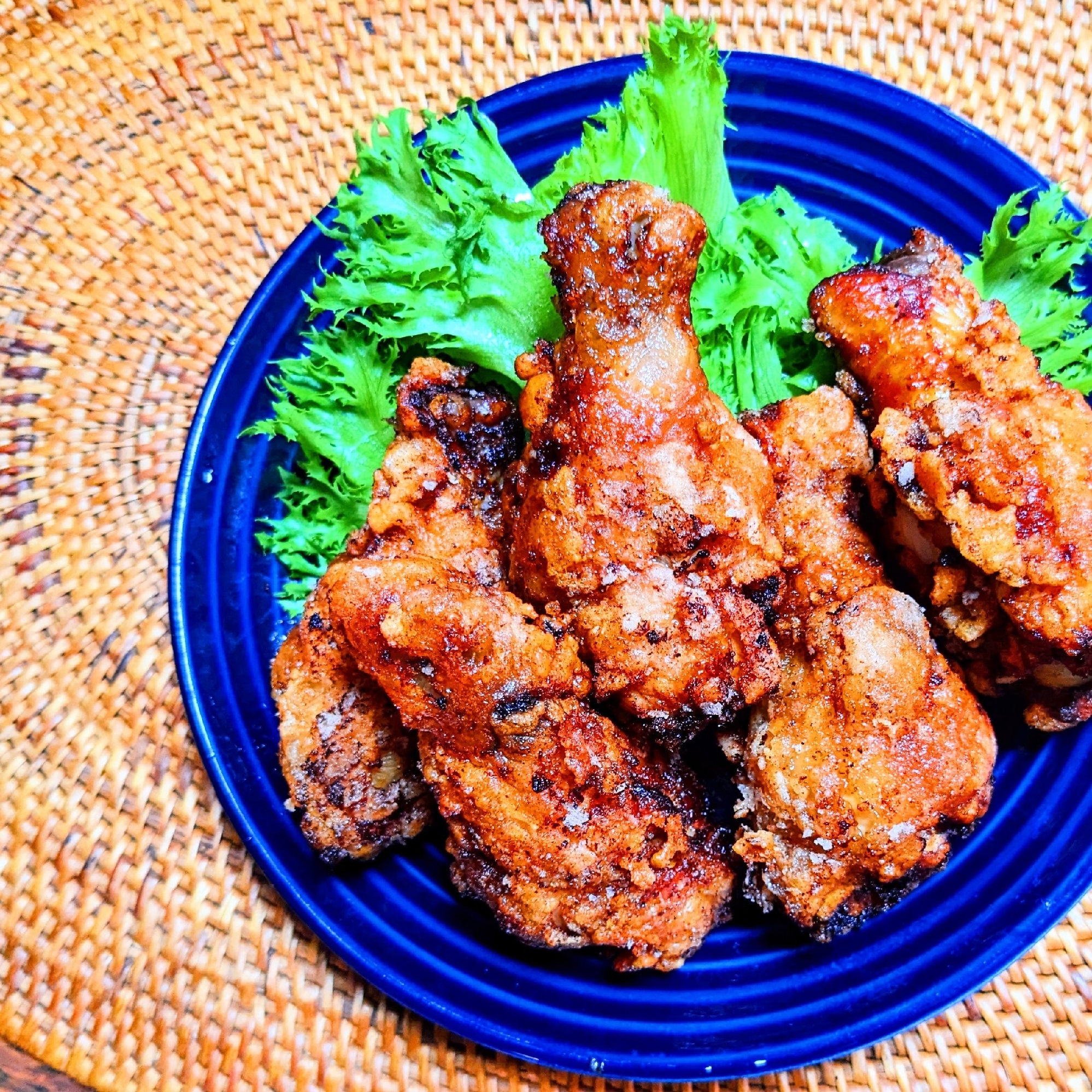 青い皿に入ったケイジャンチキンの唐揚げ