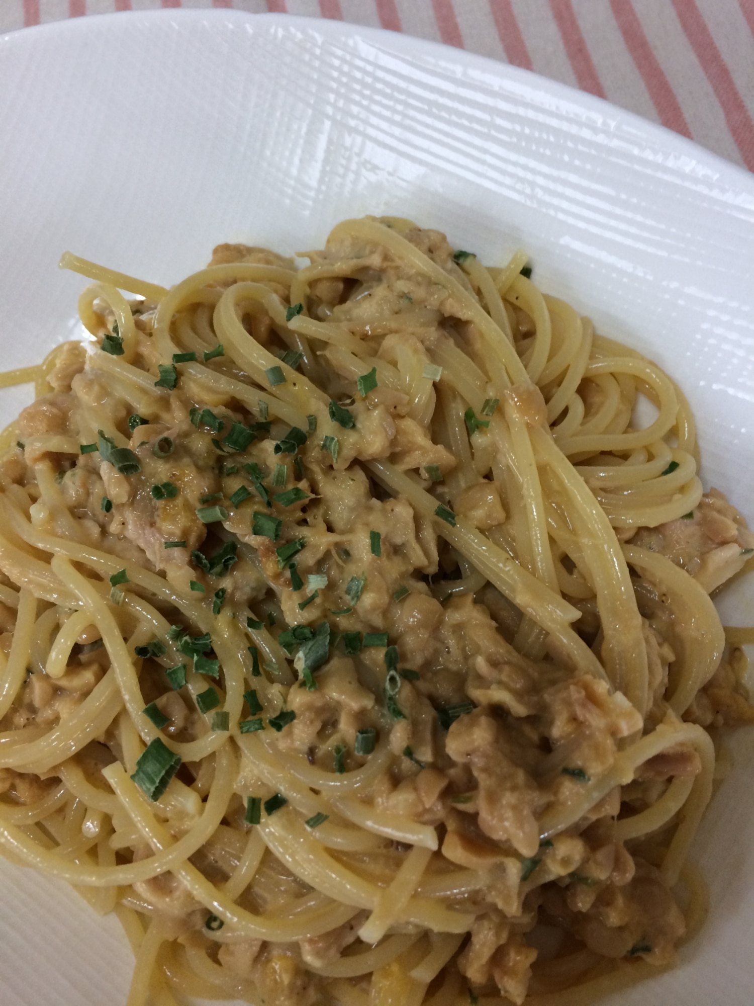 白い皿に盛り付けられたツナ缶と納豆のパスタ