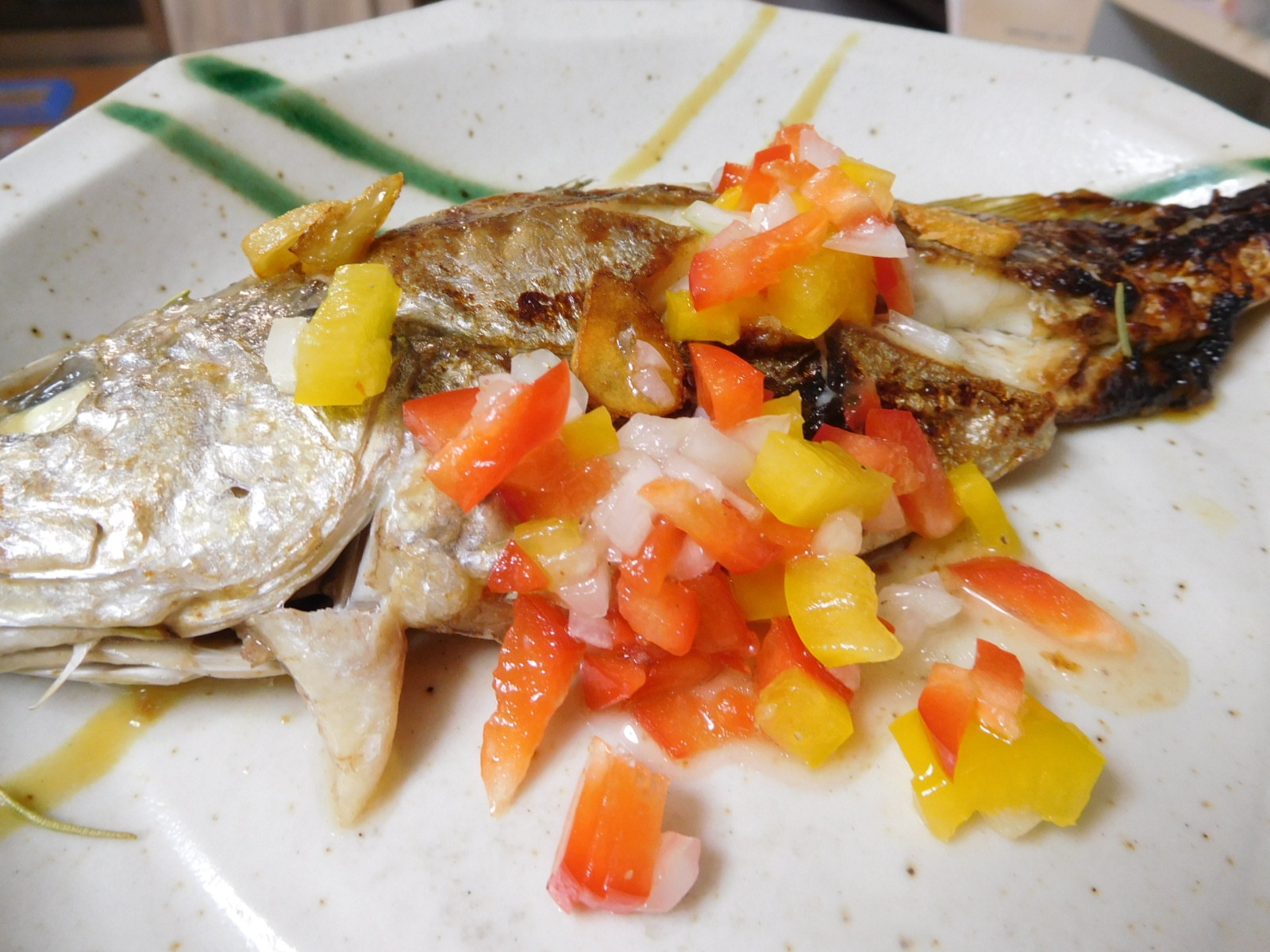 白い丸皿に盛り付けたイシモチのオリーブオイル焼き