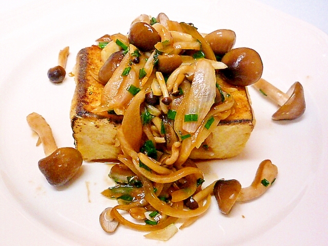 白い皿に盛り付けられたきのこソースの焼き豆腐ステーキ