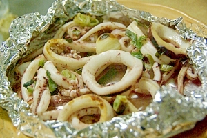 皿の上にのせた、にんにくとイカのホイル焼き