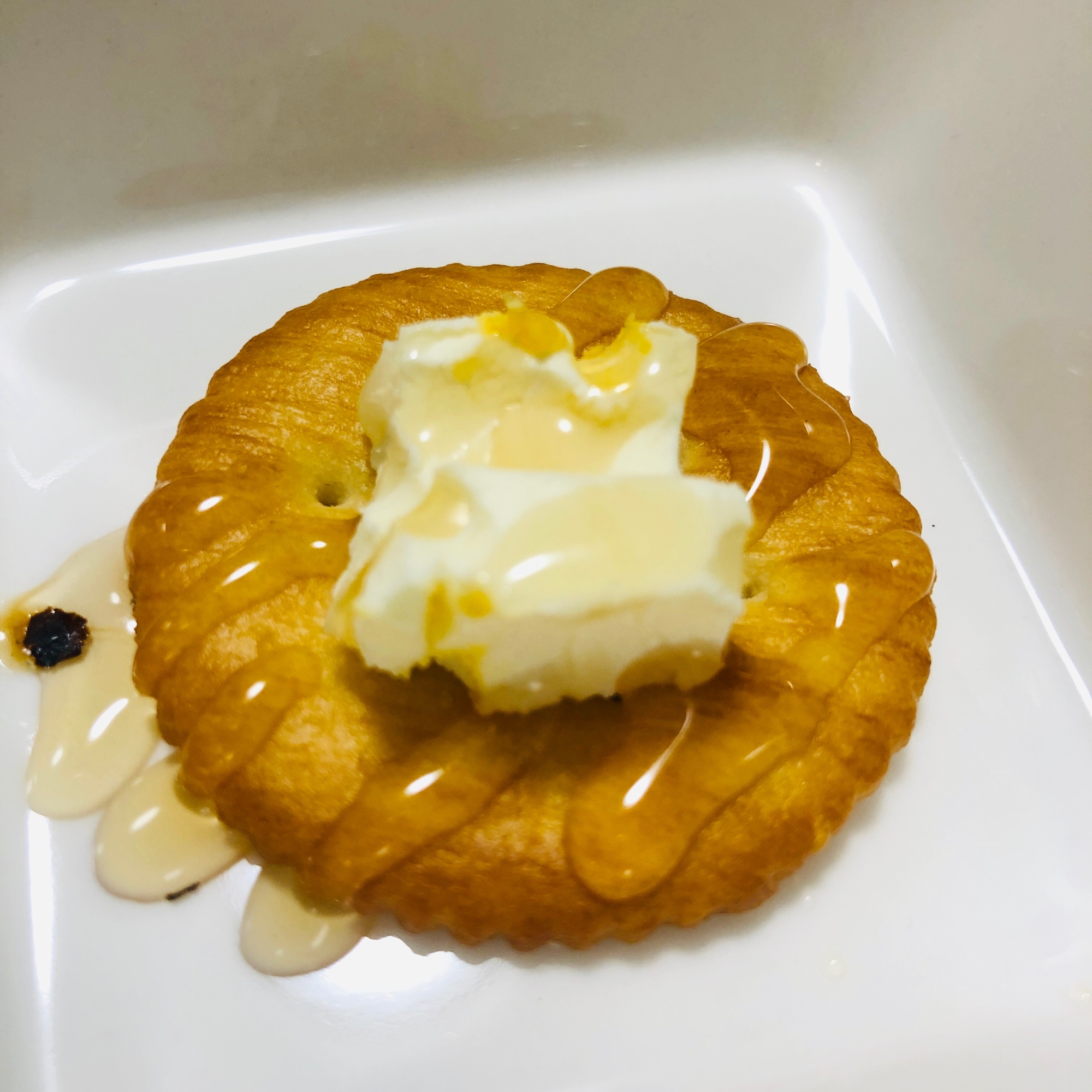 白い皿に盛り付けられた練乳クリームとはちみつのリッツ