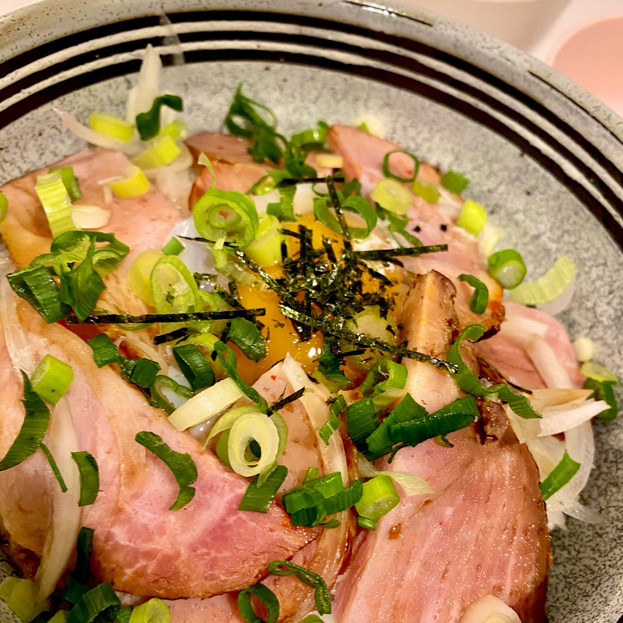 グレーの器に盛られた温玉とキムチのチャーシュー丼