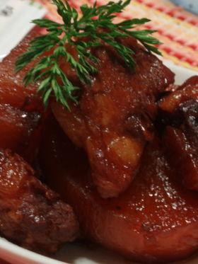 白い皿に盛られた大根と豚軟骨の黒酢煮