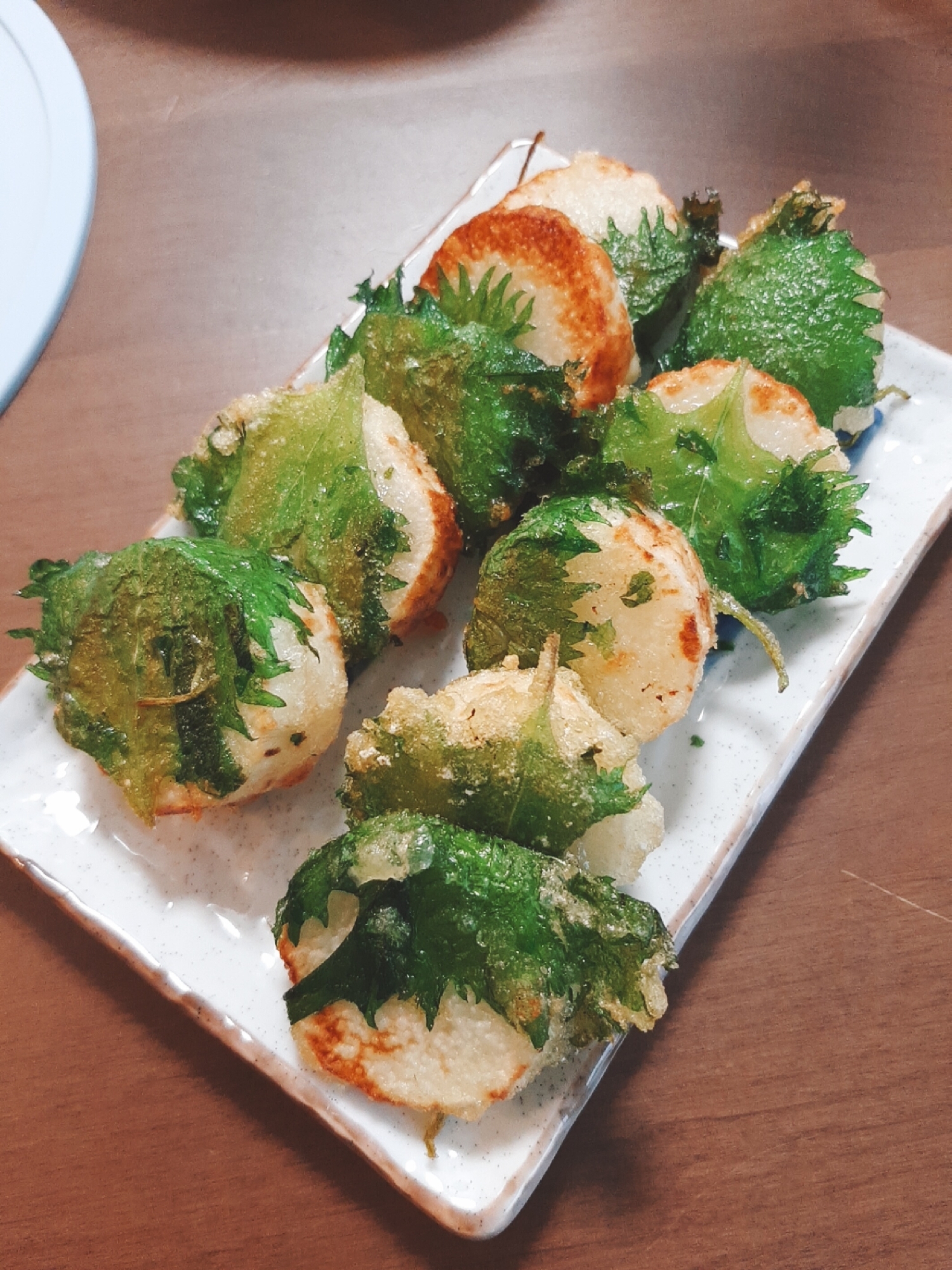 四角く白い皿に盛り付けた山芋と大葉の挟み揚げ