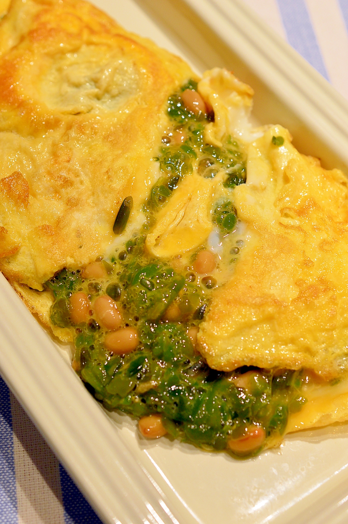 白い皿に盛られためかぶと納豆のオムレツ
