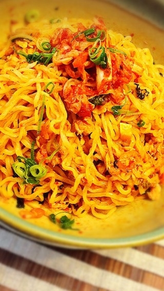 ベージュの丸皿に盛り付けた辛ラーメンキムチの混ぜそば