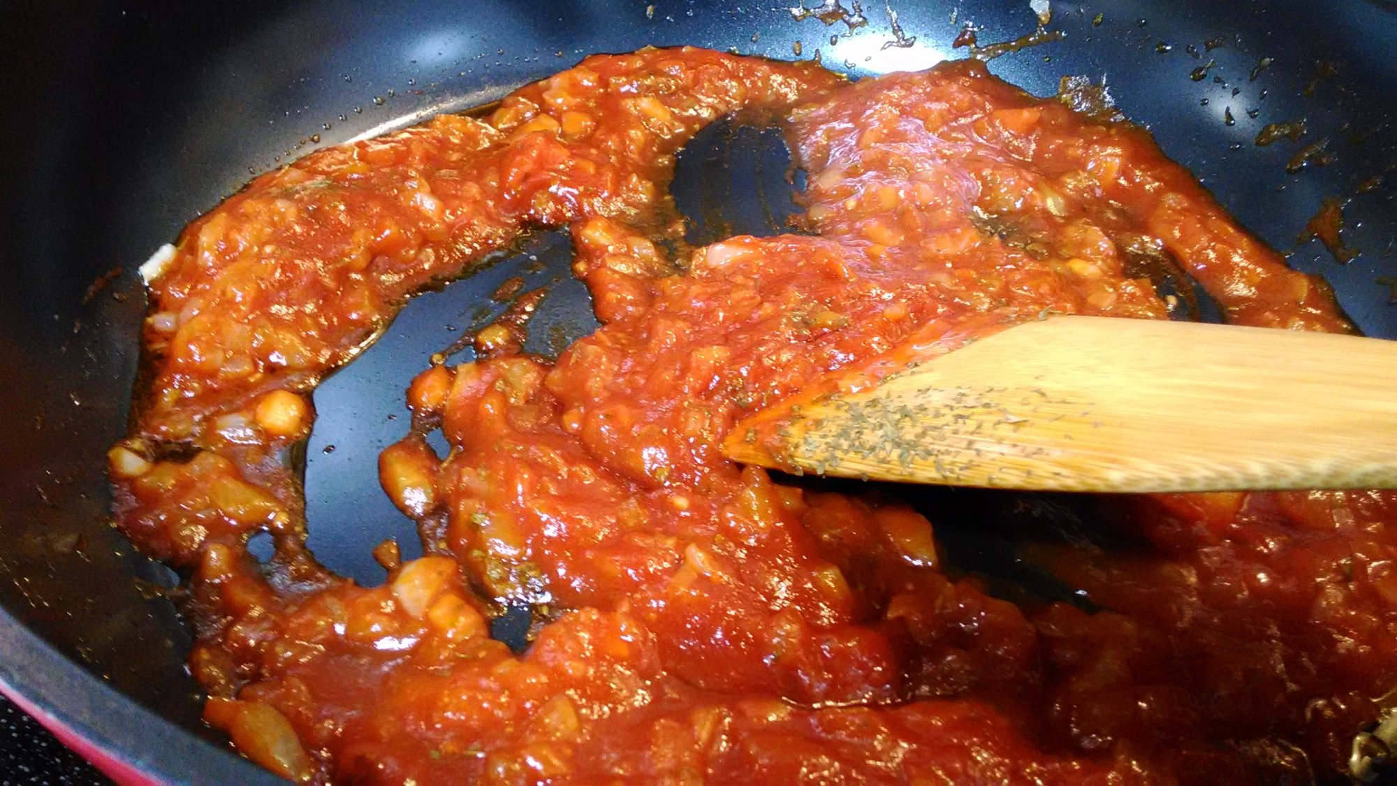 玉ねぎ入りピザソースをフライパンで炒めている様子