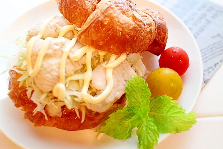 白い皿に盛られた、鶏むね肉のクロワッサンサンド