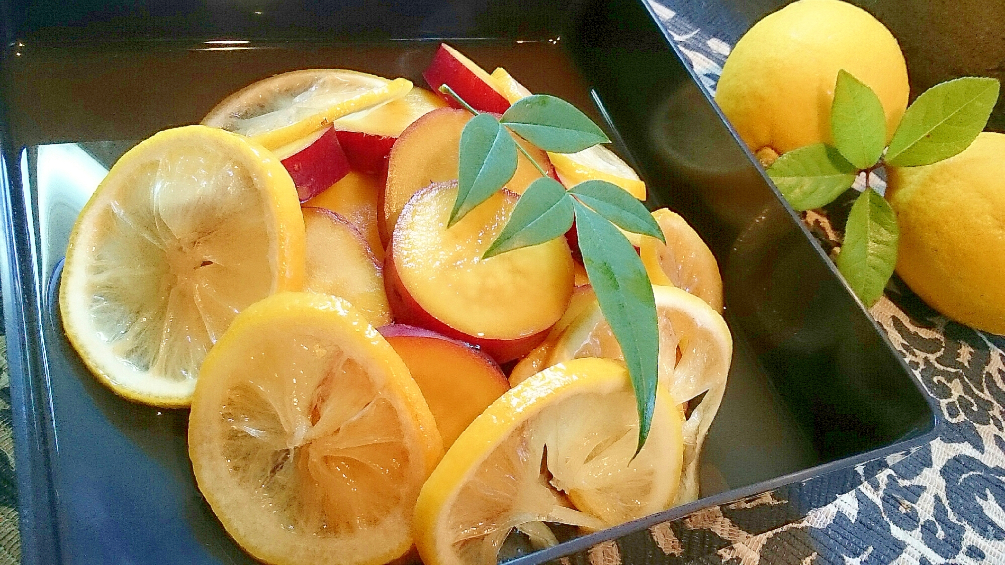 四角い黒い皿に盛り付けたさつまいものレモン煮