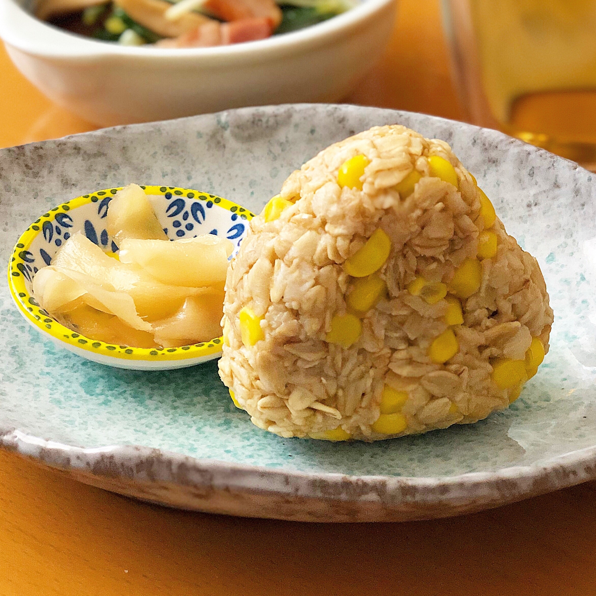 青とグレーのお皿に盛り付けられたとうもろこしのオートミールおにぎり