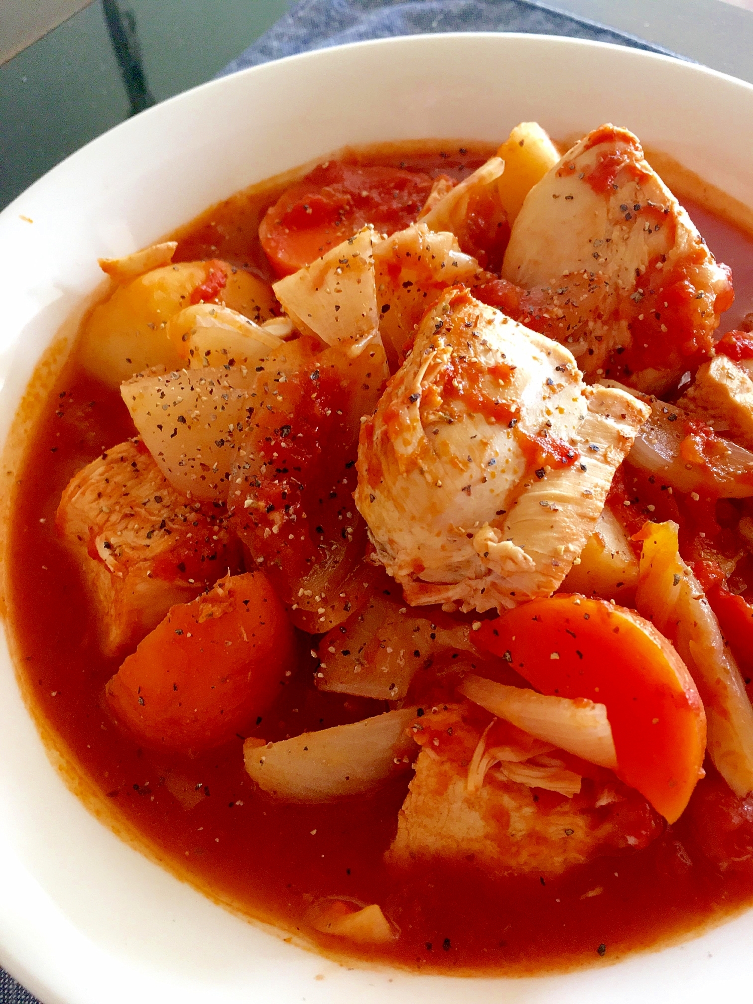 白い皿に盛られた、鶏むね肉のバジルトマトソース煮