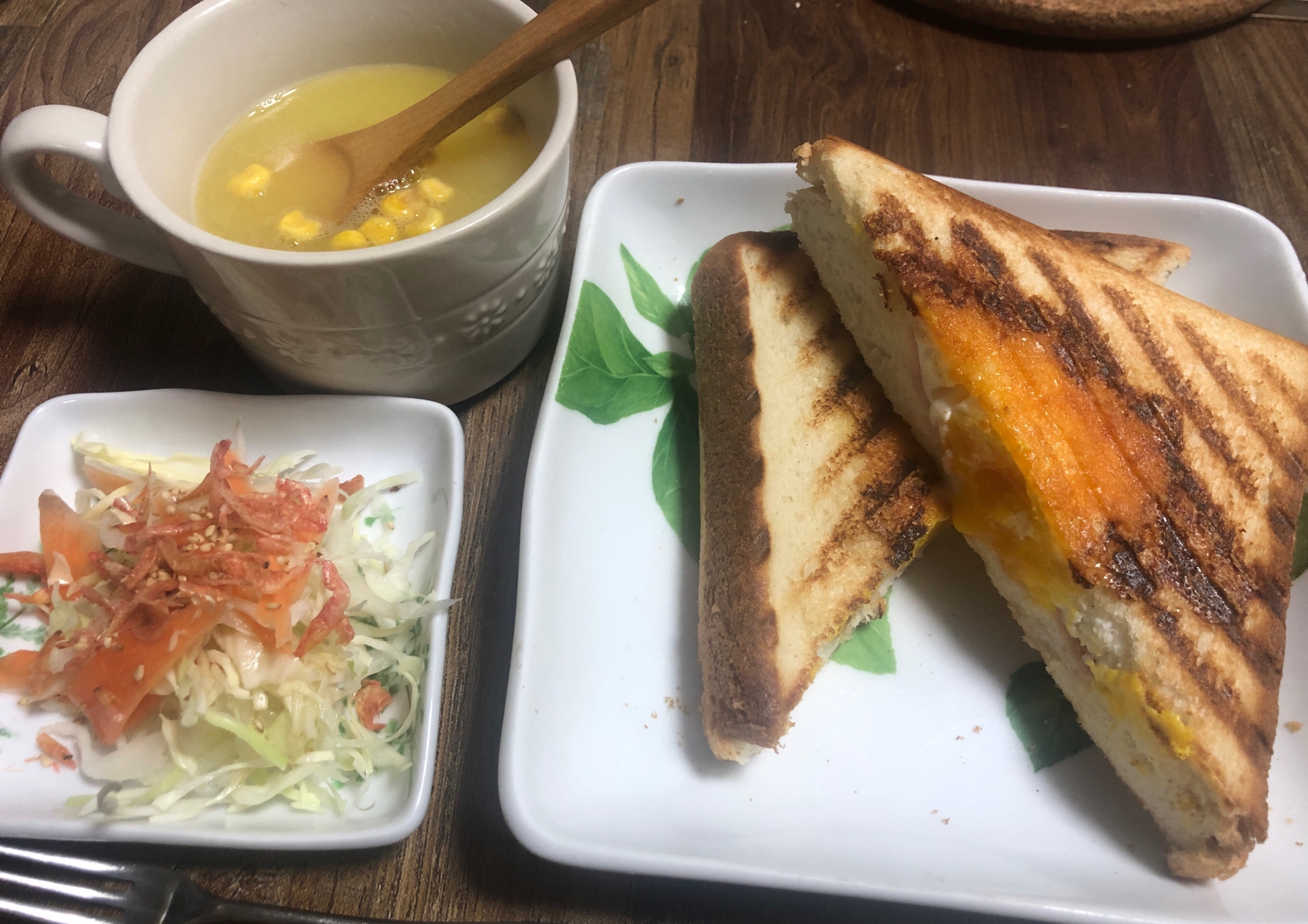 白い皿にのせたホットサンドとコーンスープとサラダ