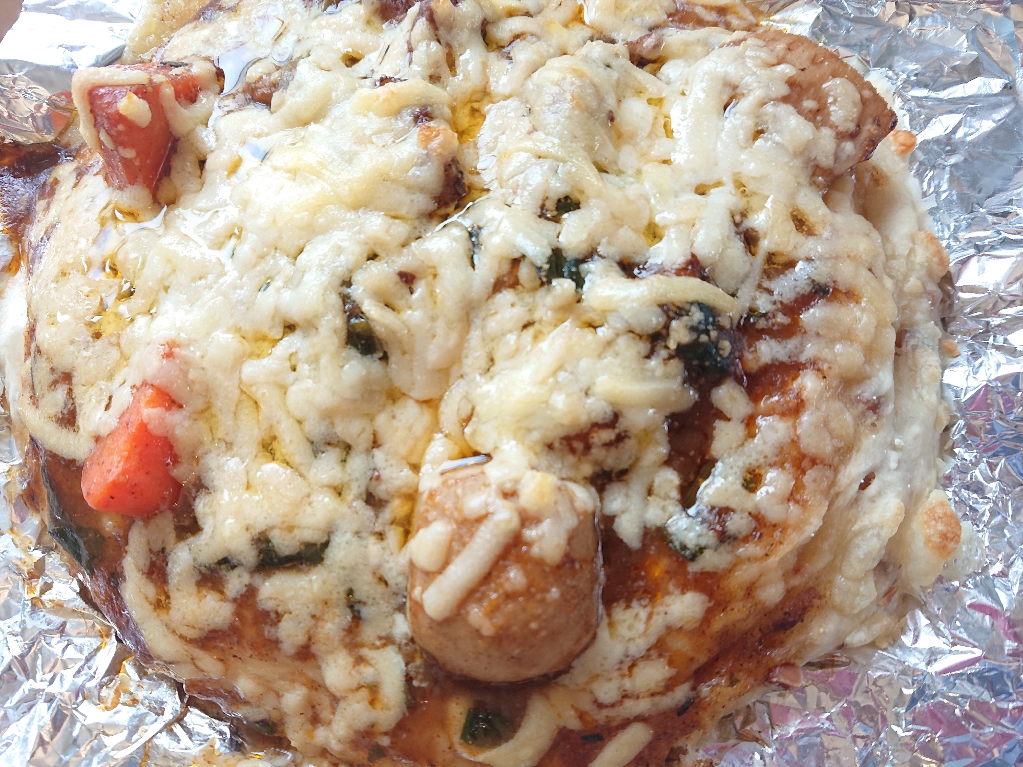 アルミホイルの上にのせられたビーフシチューのピザ