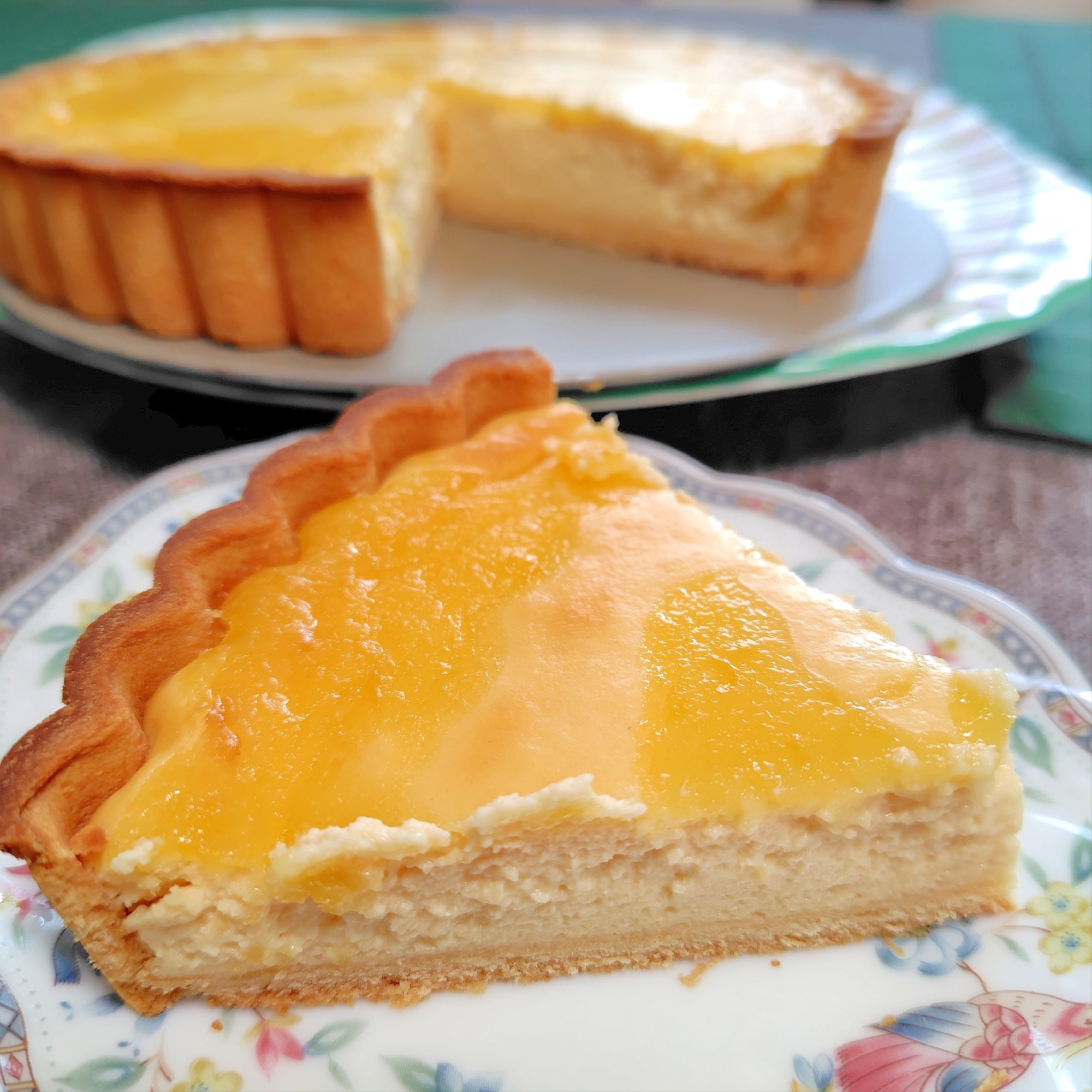 花柄の皿に盛り付けられたレモンカードのチーズケーキタルト