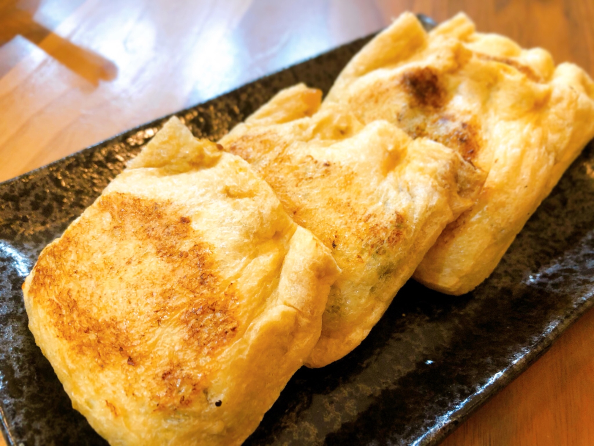 黒色の皿に盛られたカレー巾着