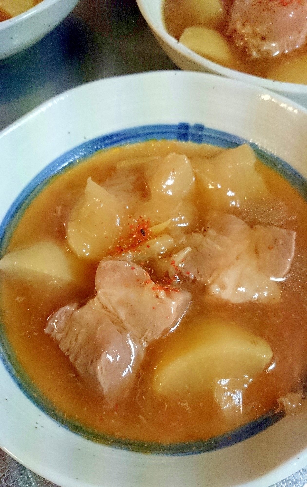 白い皿に入った豚肉と大根の甘辛煮